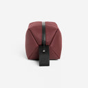 A studio shot of the grab handle and end of the Garnet Red Wash Bag