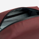 A studio shot of the interior zip pocket in the Garnet Red Wash Bag