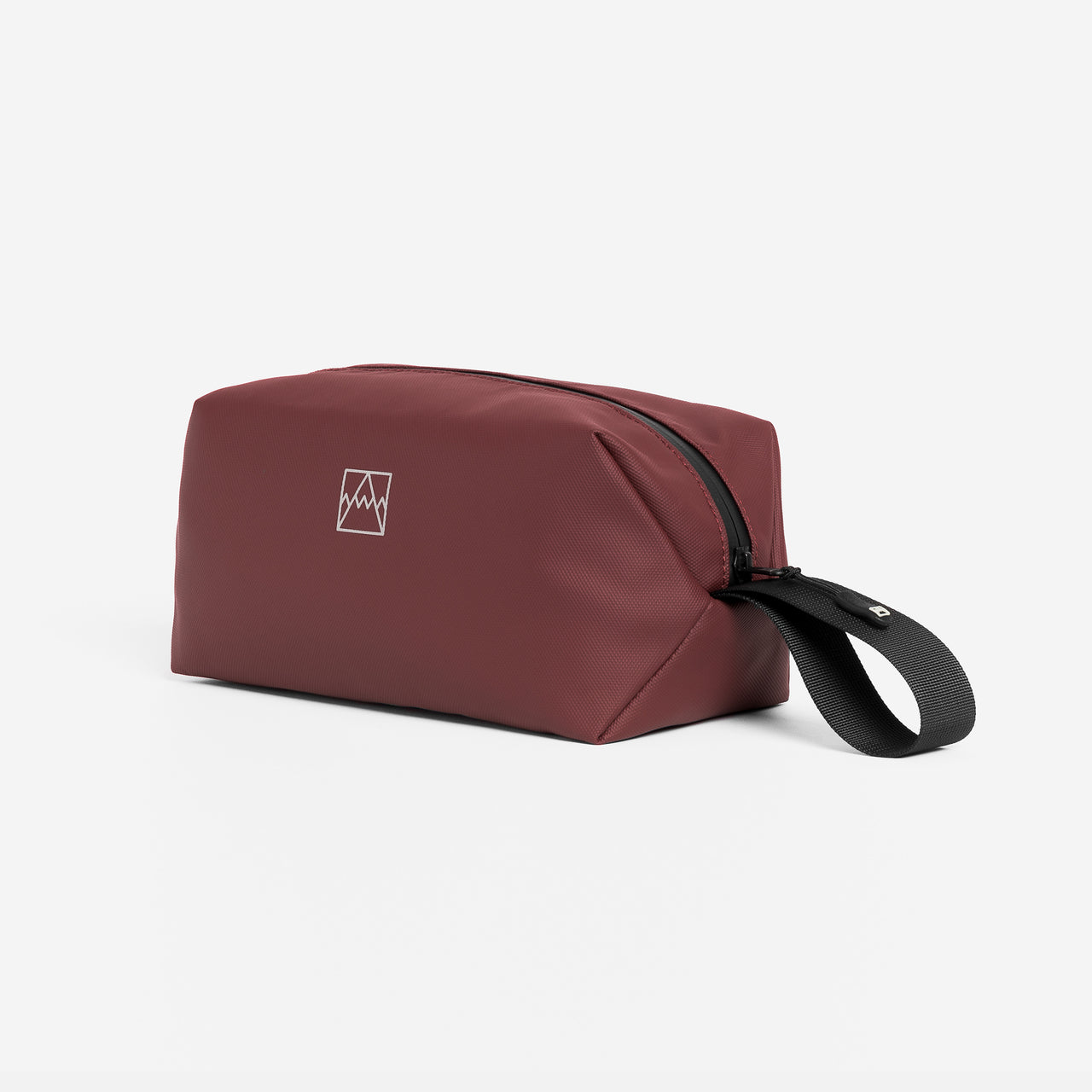A studio shot of the side and grab handle on the Garnet Red Wash Bag