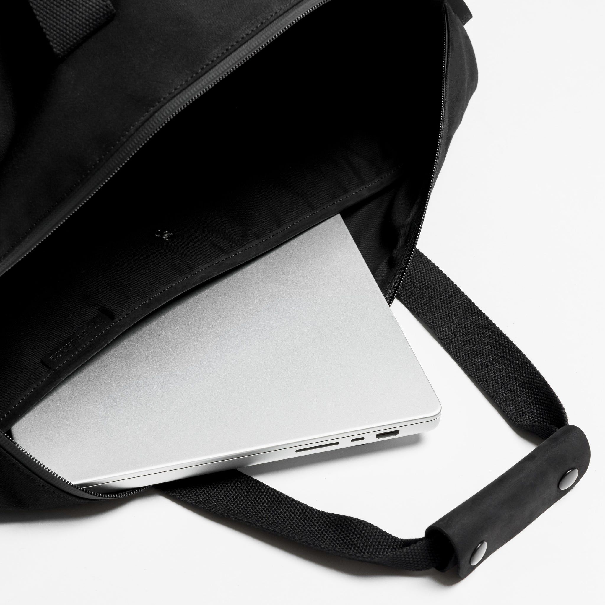 A studio shot of the laptop compartment in a weekender 30l in All Black