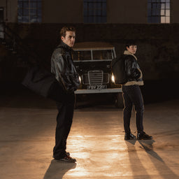 A man wearing a Weekender 30L in All Black on his shoulder with a woman wearing the Backpack 20l on her back