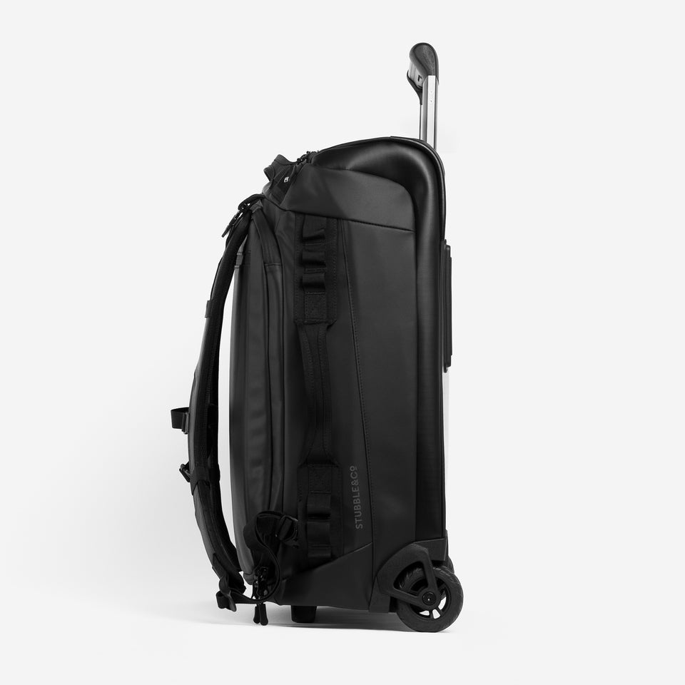 A studio shot of the Wheeled Kit Bag 40L in All Black on its side and the handle half way up