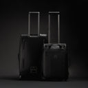 A studio shot of the Wheeled Duffel 80L and 40L side by side showing the front and back in All Black