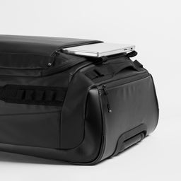 A studio shot of the Wheeled Kit Bag 80L in All Black showing the 17" laptop compartment
