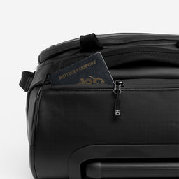 A studio shot of the easy access pocket on the end of an All Black wheeled kit bag 40l