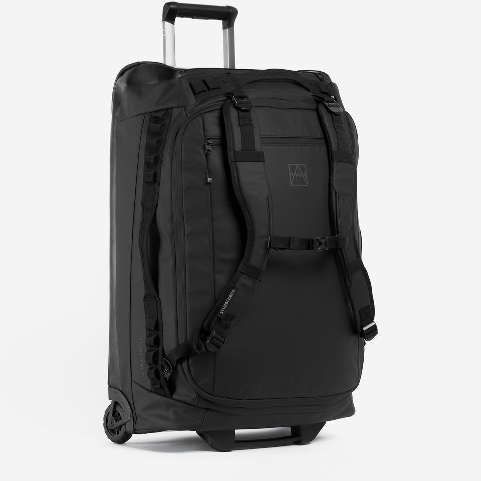 A Wheeled Duffel 80L in black with the telescopic handle extended.