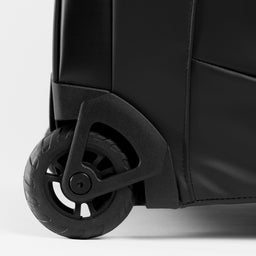 A studio shot of the All Black Wheeled Duffel 80L in All Black.  It shows the multi-terrain wheels