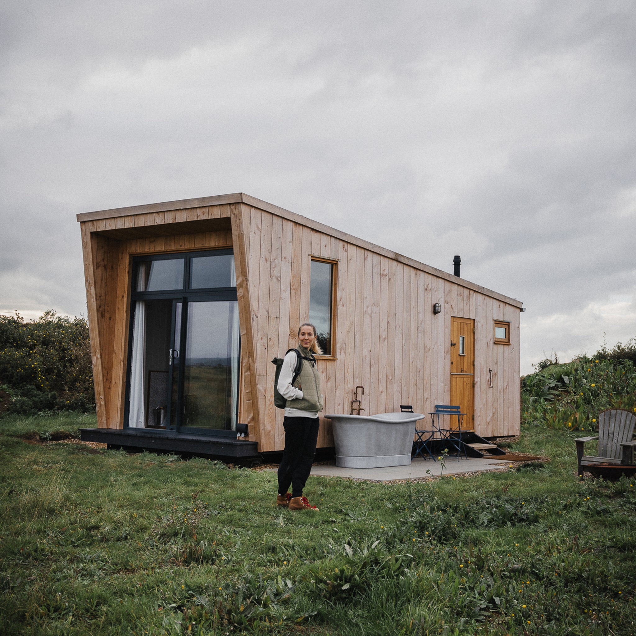 a woman standing by a cabin- the travel project blog