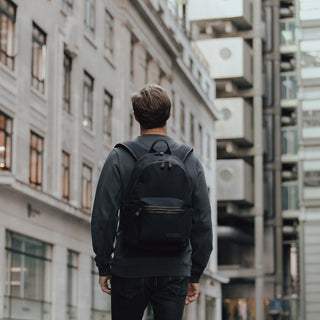 Back view of a man wearing a Commuter in Black walking down the street.