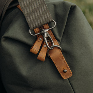 Close up of the side of The Olive Weekender, showing the brown leather zip tabs.