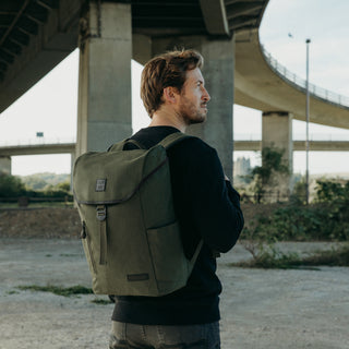 A man wearing The Backpack in Olive.