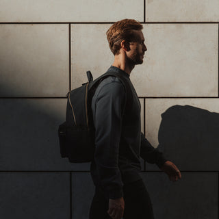 Side view of a man walking while wearing a Commuter in Black.