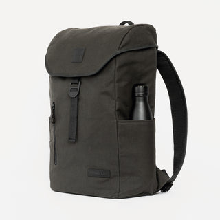 Side view of The Backpack in Pirate with a 500ml water bottle in the side pocket.