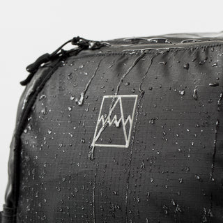 A close up of The Adventure Bag with water beading off it.